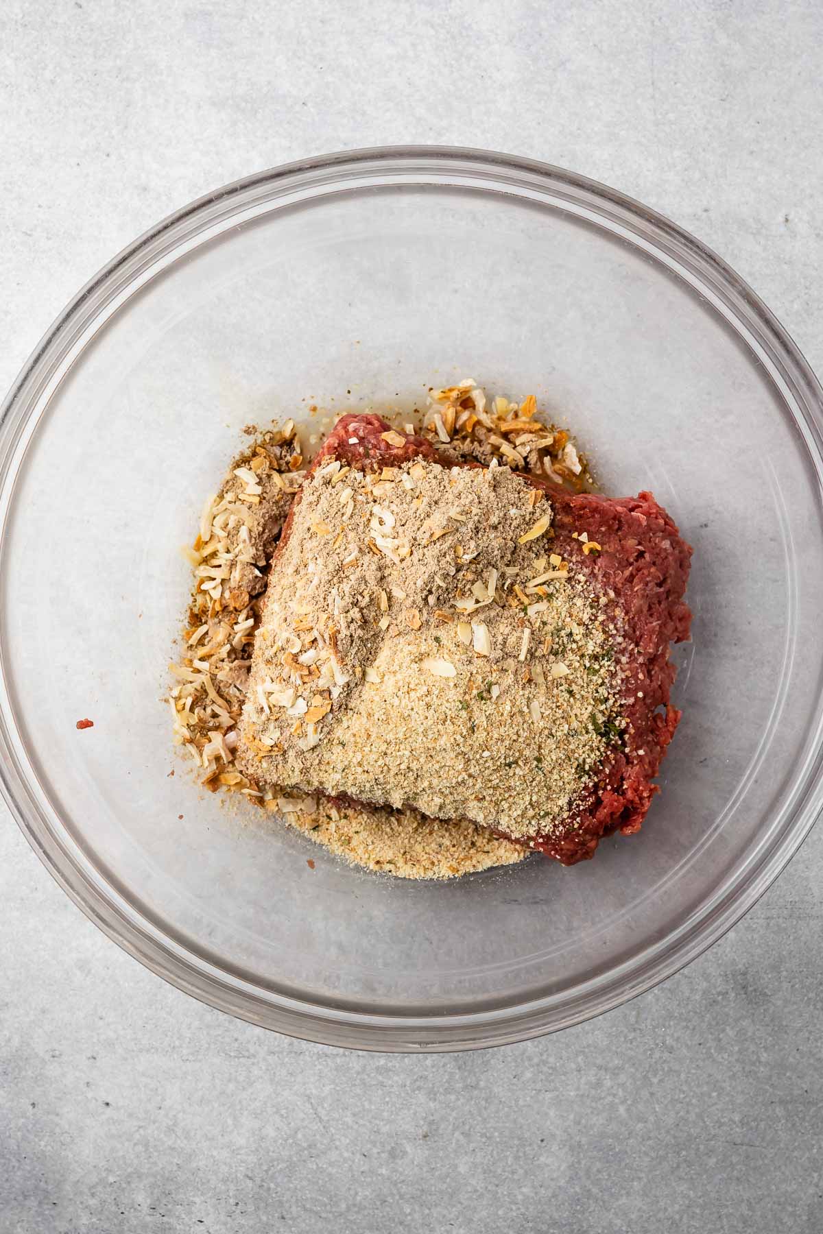 beef in a clear bowl with seasoning on top