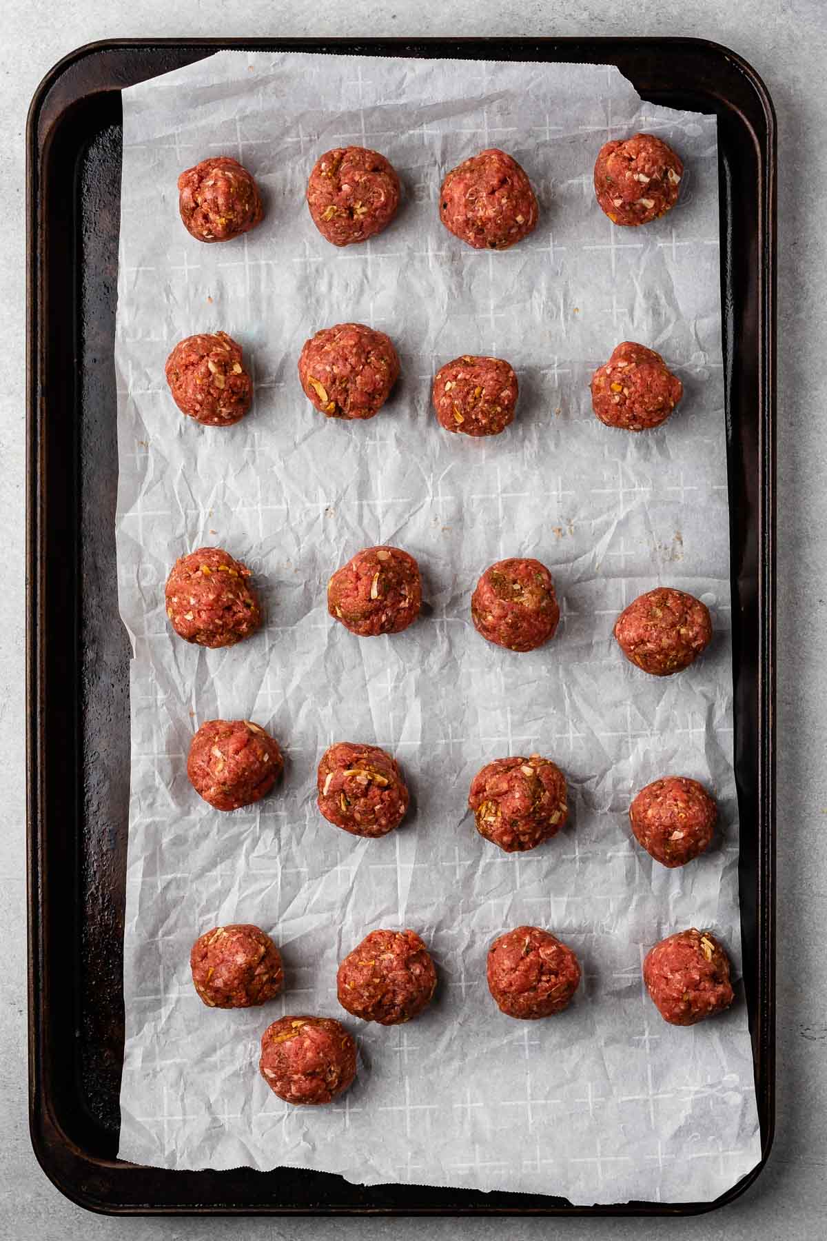 meatballs before being cooked on a pan with parchment paper