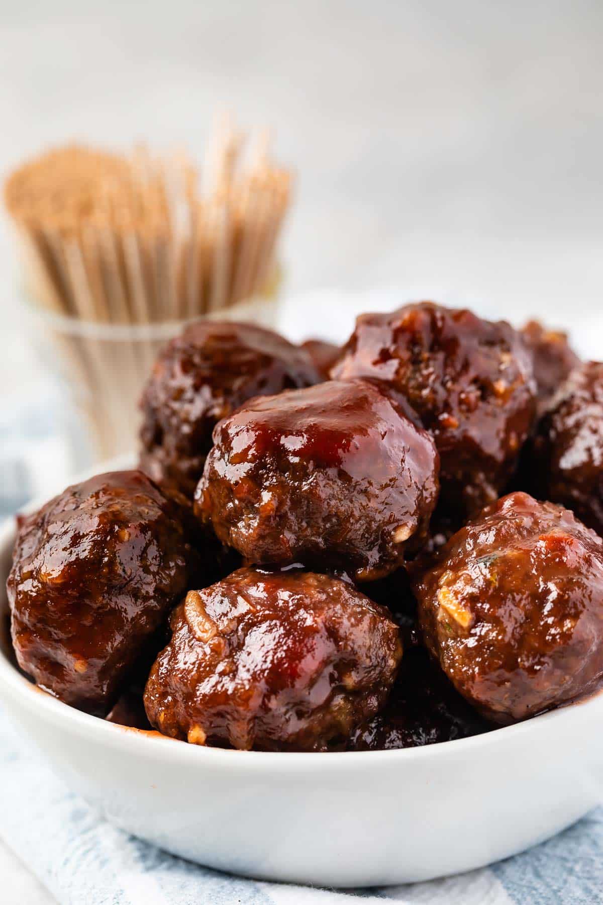 multiple meatballs stacked in a white bowl