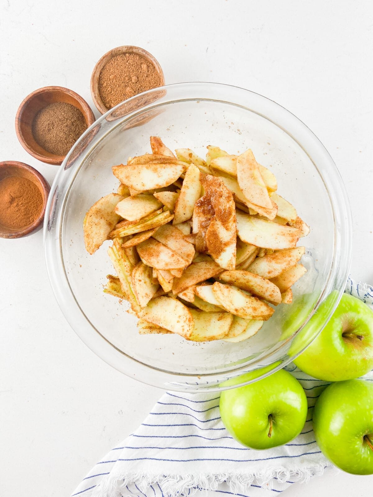 bowl of apples with spices and sugar on them.