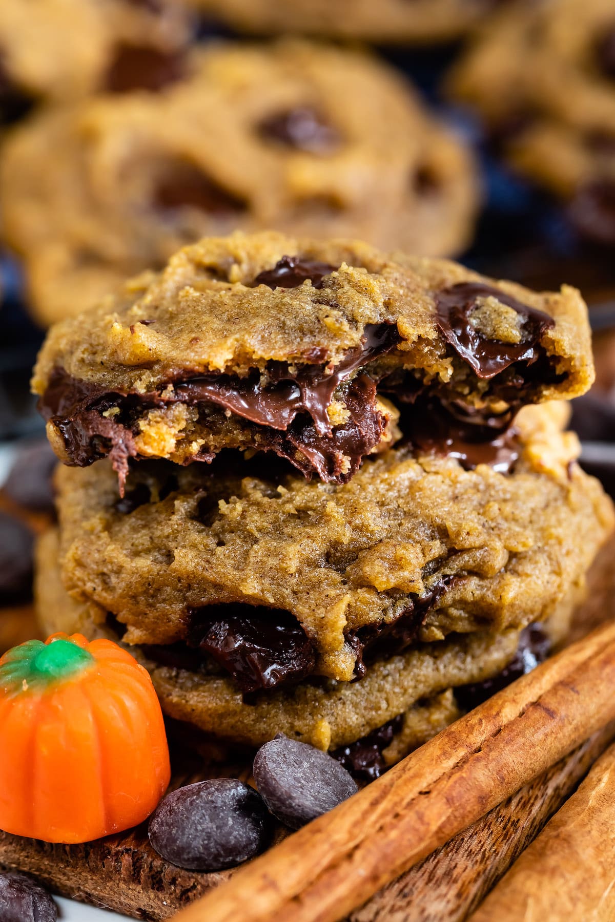 stacked pumpkin cookies with chocolate chips baked in and the cookie on top cut in half