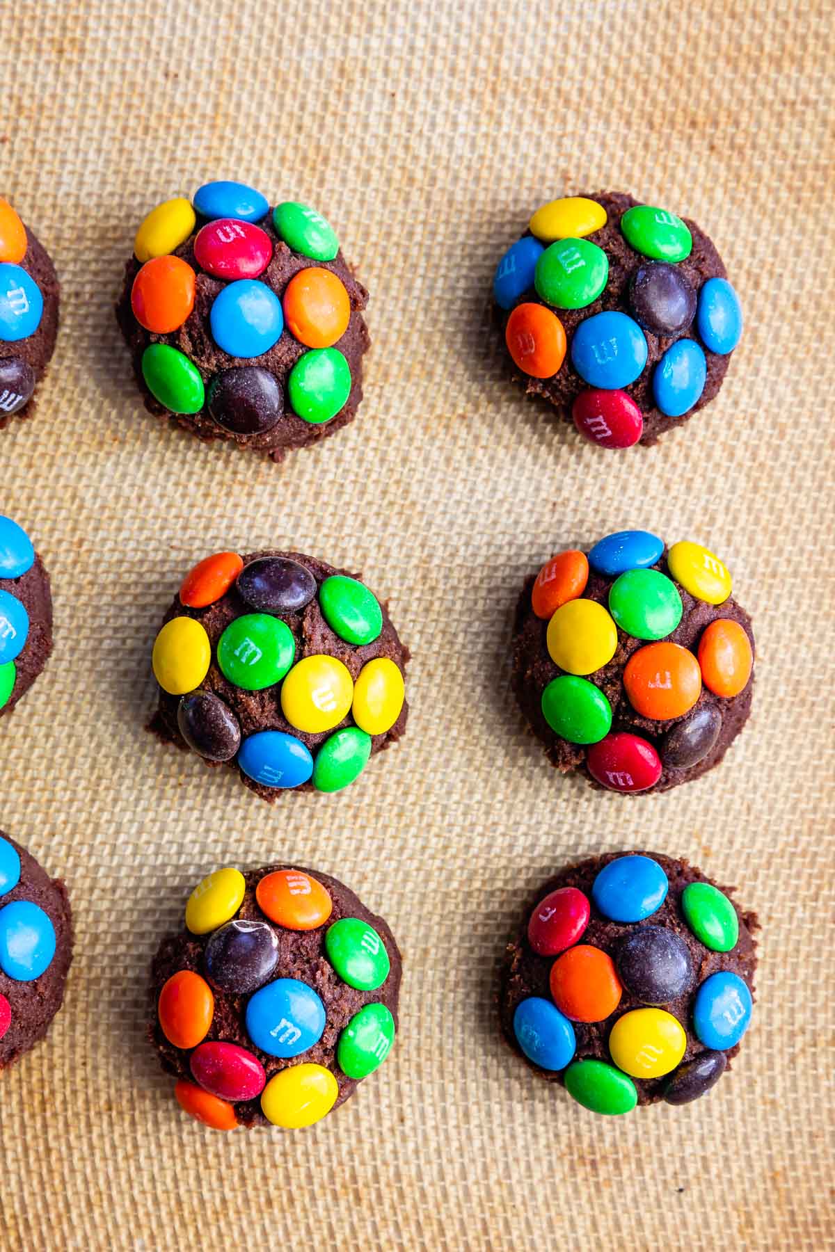 balls of chocolate dough with m&ms pressed in