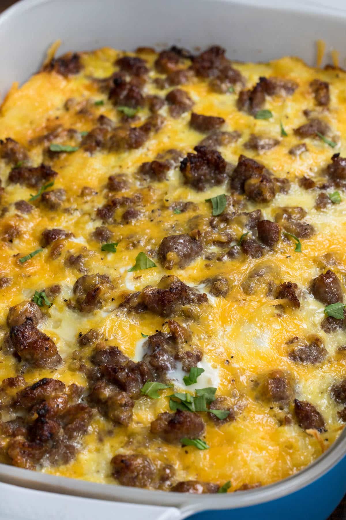 egg casserole with sausage on top in a blue pan