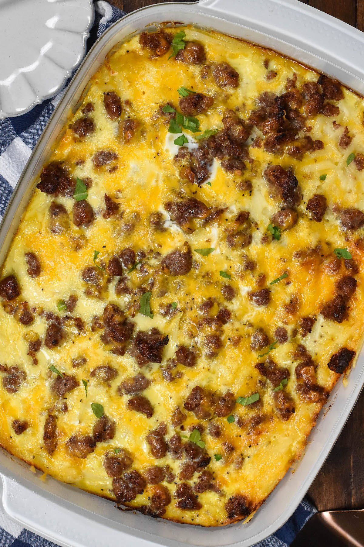 egg casserole with sausage on top in a white pan