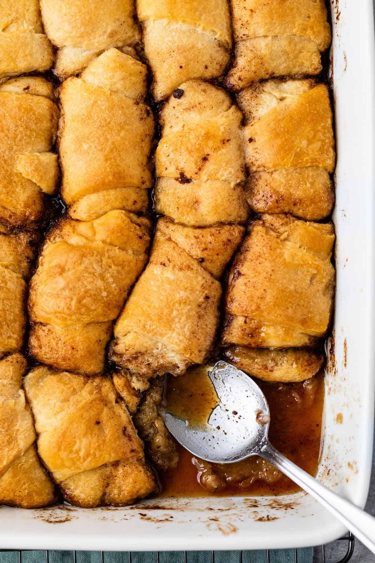 multiple dumplings laid in a pan with a silver spoon around