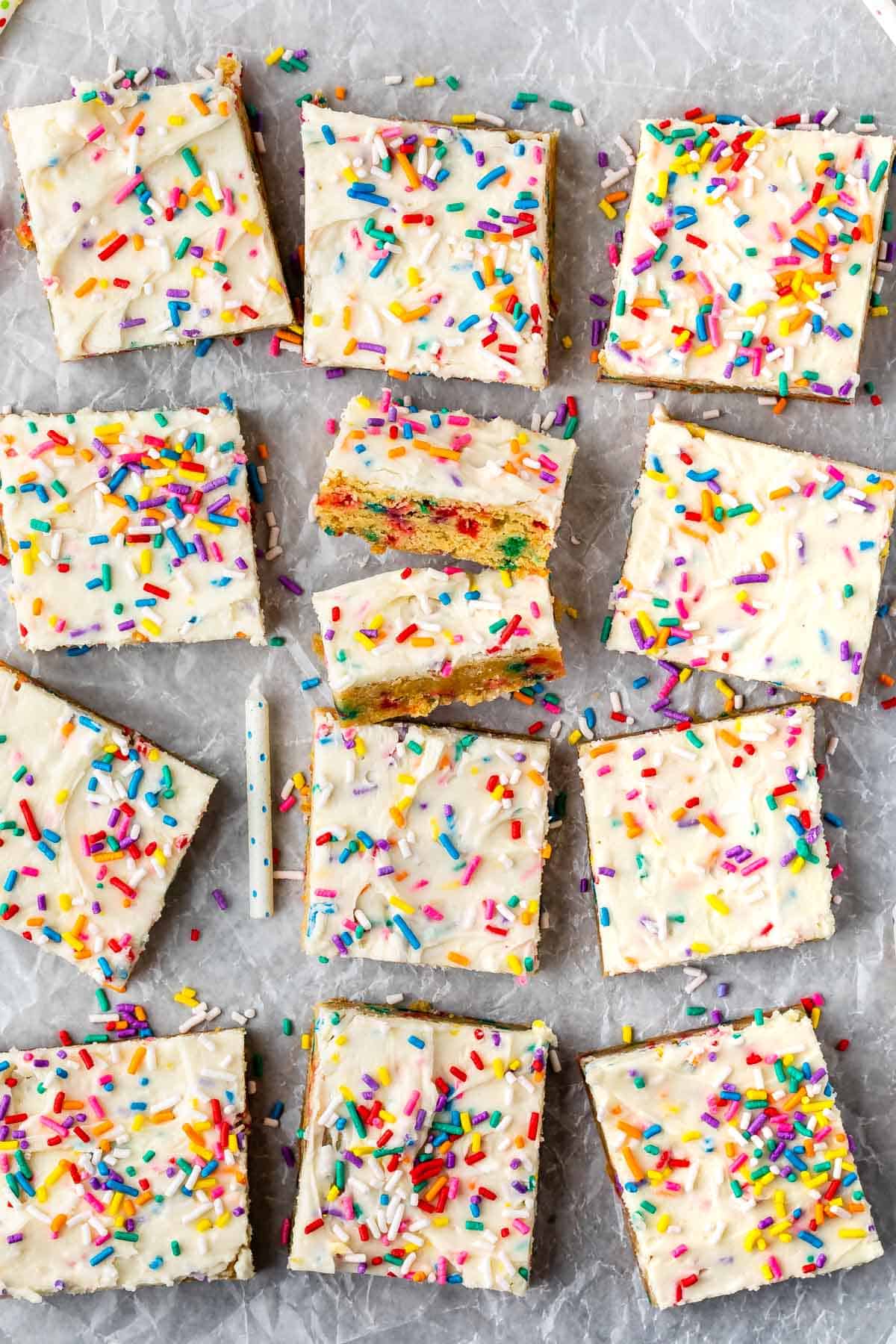 funfetti bars laid out on parchment paper with rainbow sprinkled sprinkled on top