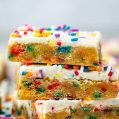 stacked cookie bars with colorful rainbow sprinkles baked in and sprinkled on top