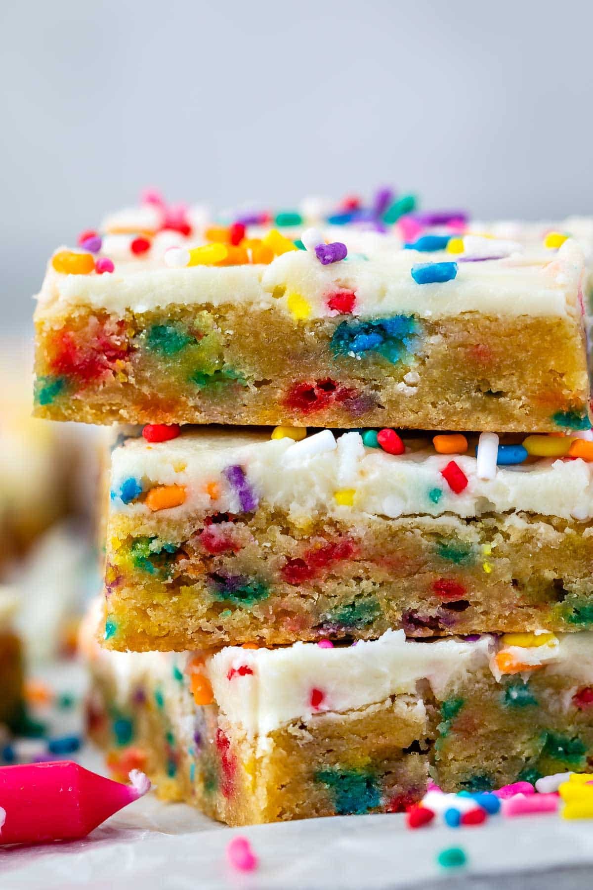 stacked cookie bars with colorful rainbow sprinkles baked in and sprinkled on top
