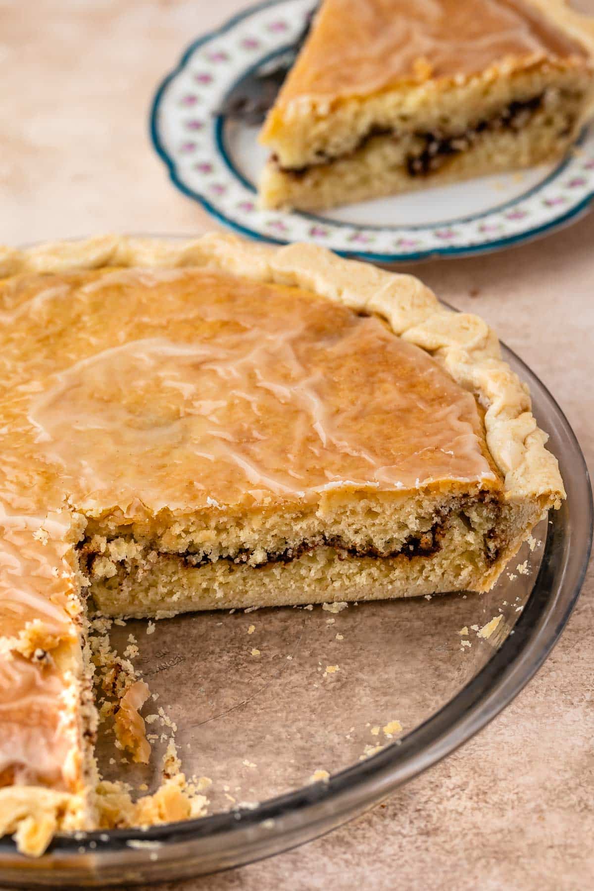 snickerdoodle pie in a clear pie pan with a slice taken out