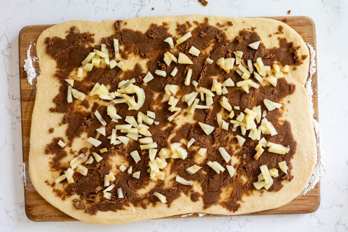 rolled out dough spread with cinnamon mixture and apples.