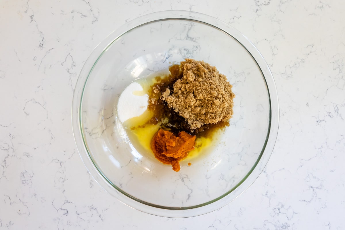 clear glass bowl with melted butter, sugars, and pumpkin.