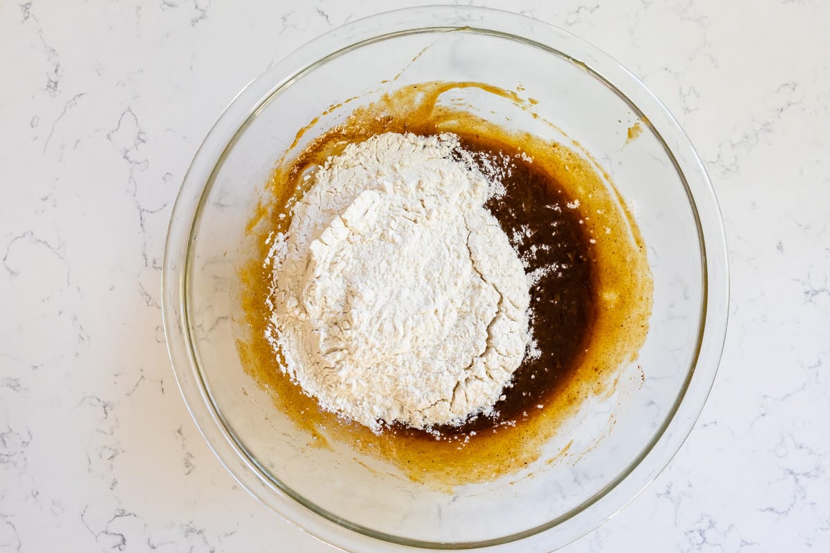 clear glass bowl with pumpkin mixture with flour.