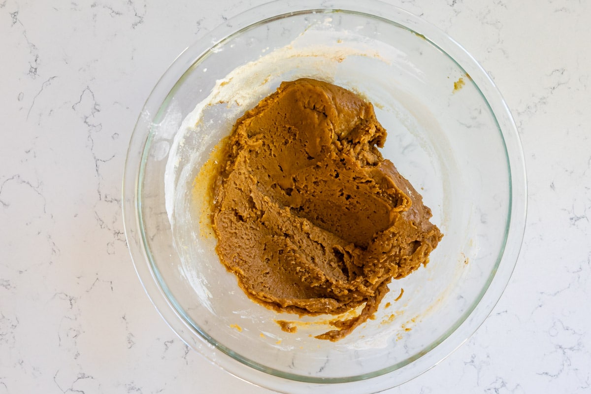 clear glass bowl with pumpkin cookie dough.