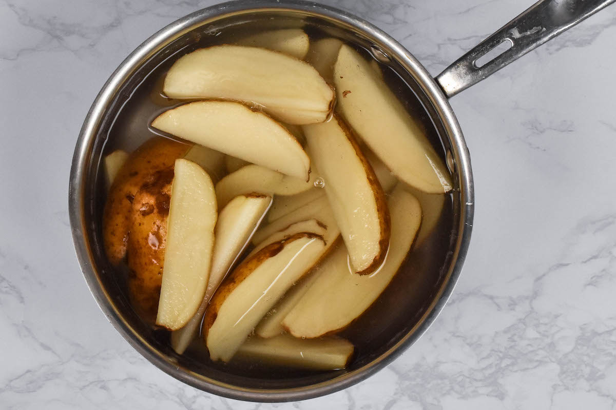 pan of potato wedges covered with water