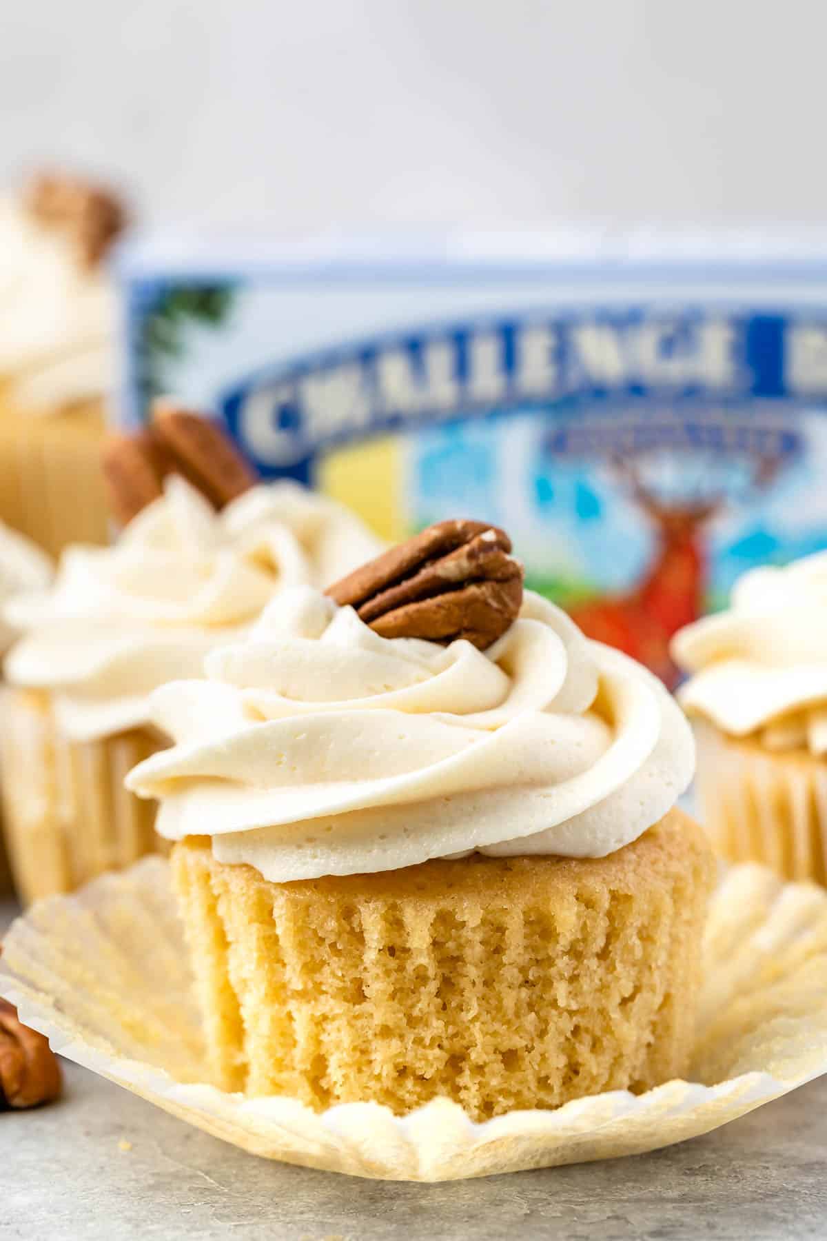 pecan cupcake with white frosting and a pecan on top