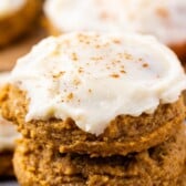 stacked pumpkin cookies with frosting on top and words on top