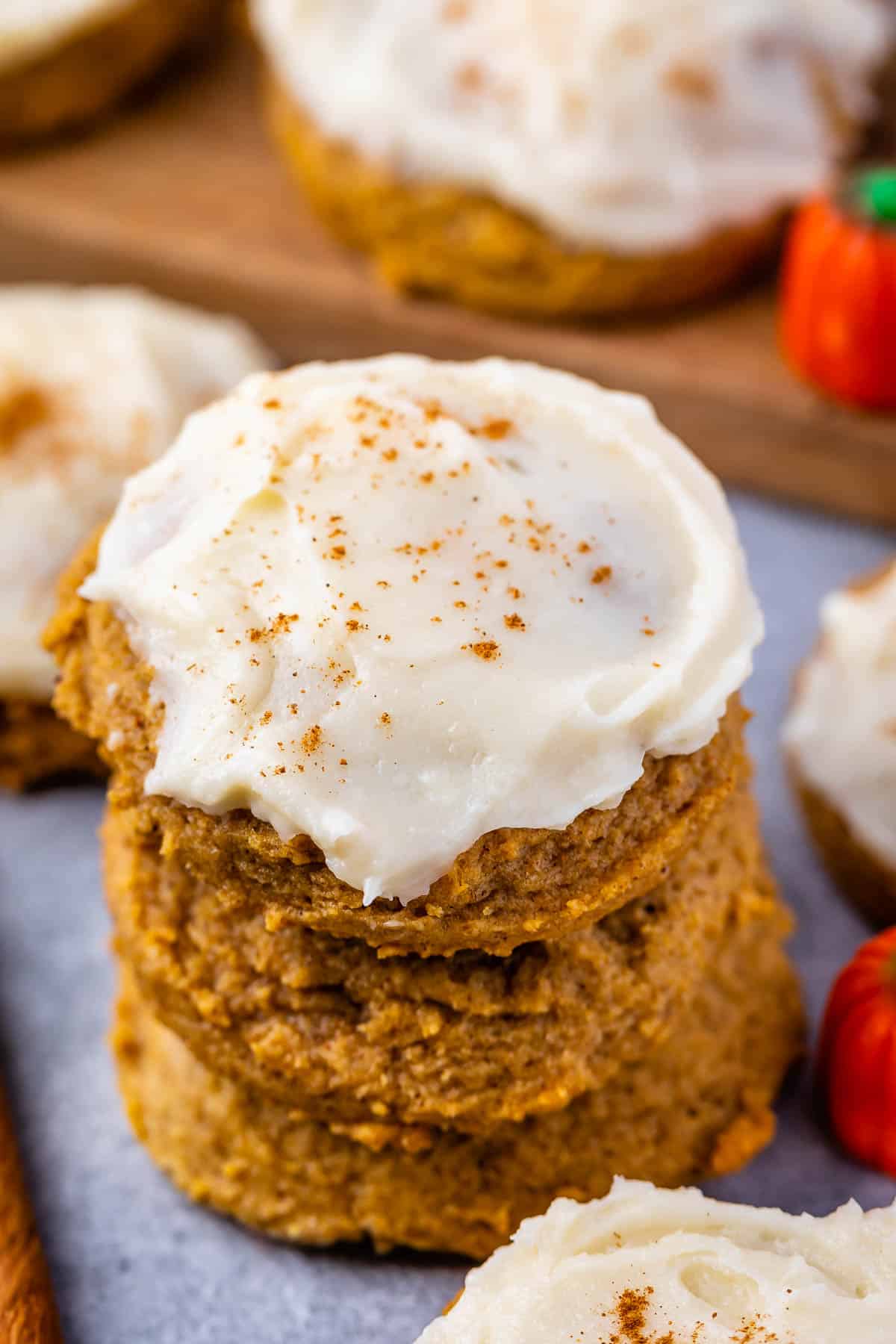 stacked pumpkin cookies with frosting on top