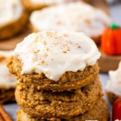 stacked pumpkin cookies with frosting on top