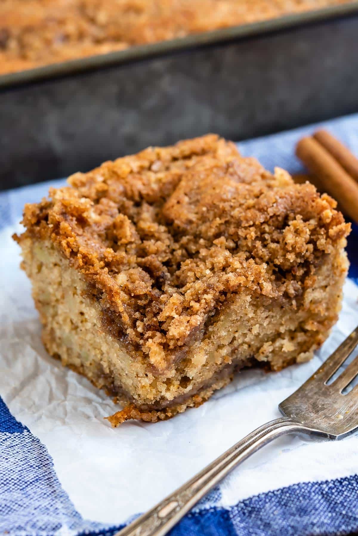 crumb cake on a white towel next to a silver fork