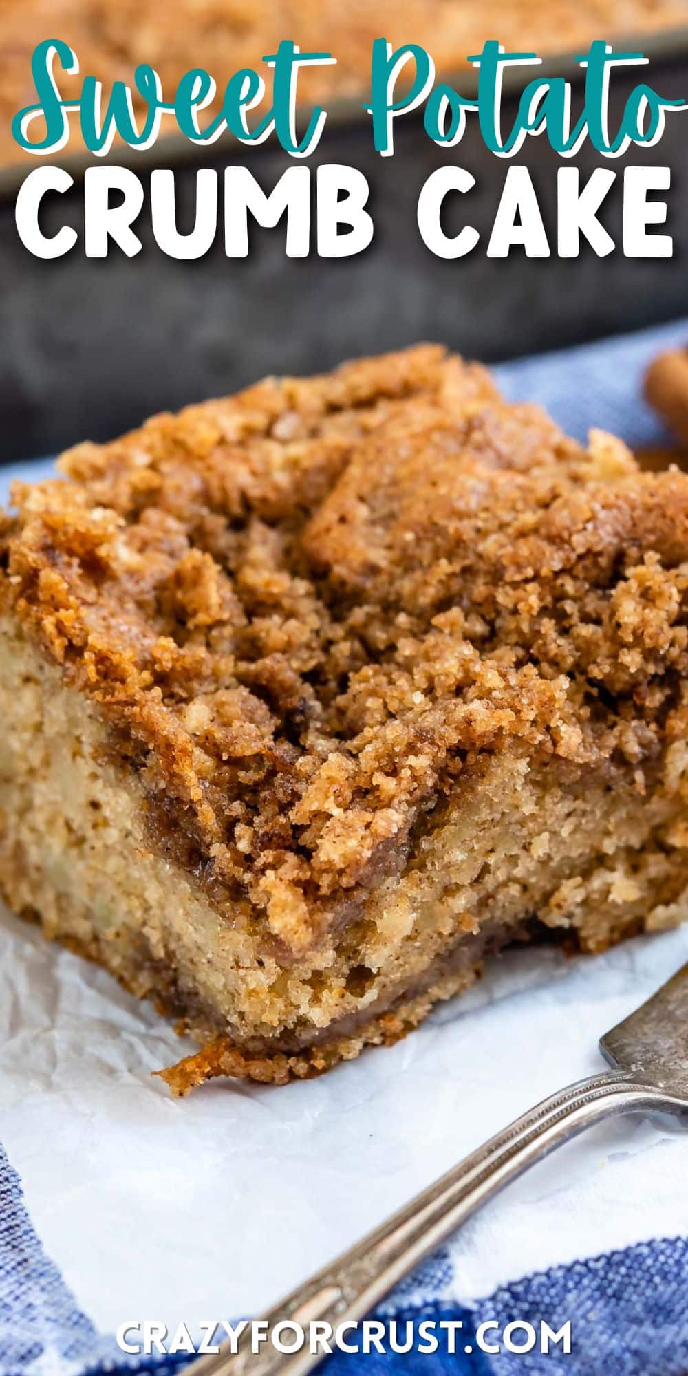 crumb cake on a white towel next to a silver fork with words on top