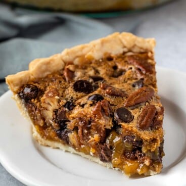 slice of pecan pie with toffee in it on a white plate