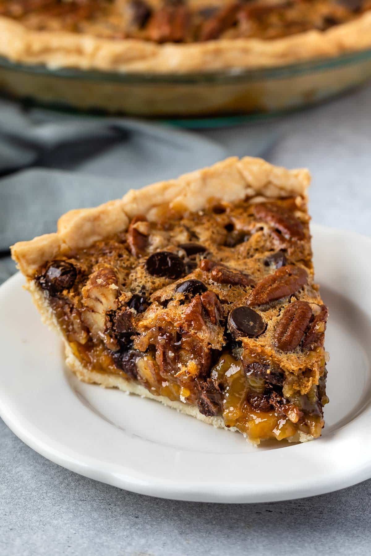 slice of pecan pie with toffee in it on a white plate