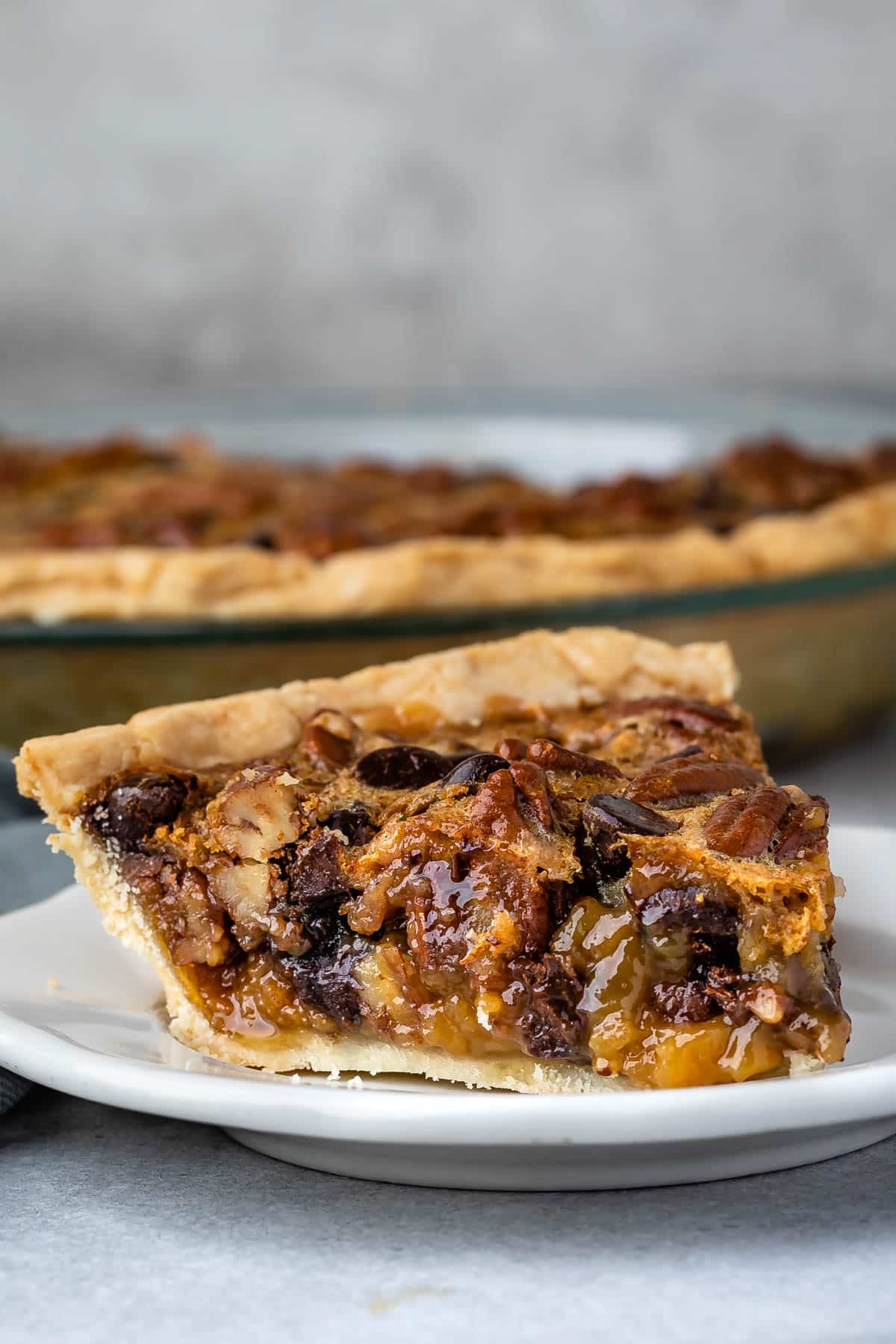 slice of pecan pie with toffee in it on a white plate