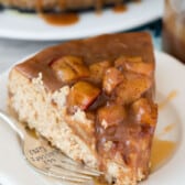 a slice of cheesecake with apples baked on top on a white plate