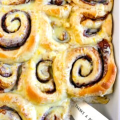 sweet rolls in a white pan baked together with frosting poured on top
