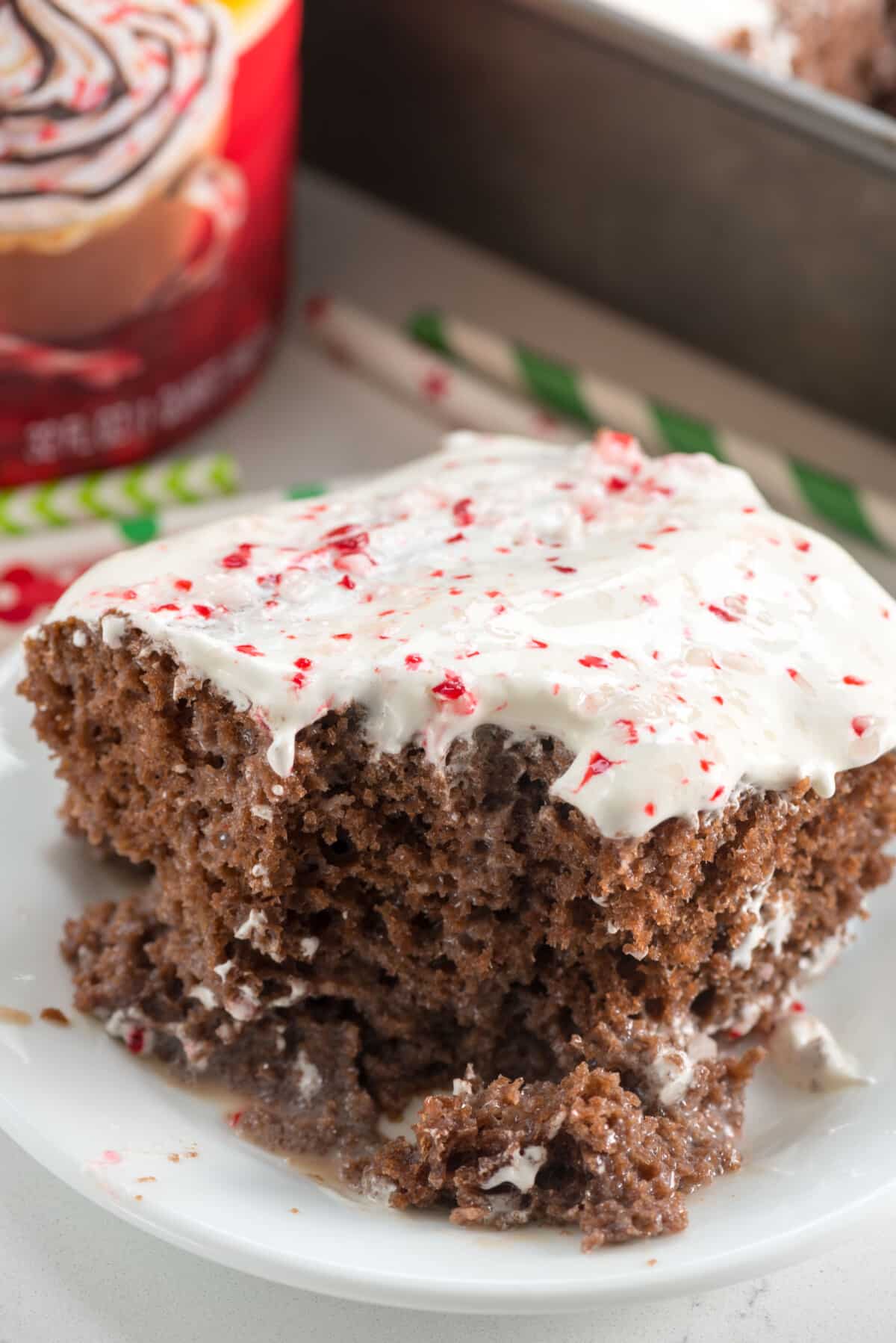 cake with white frosting and crushed peppermint on top on a white plate