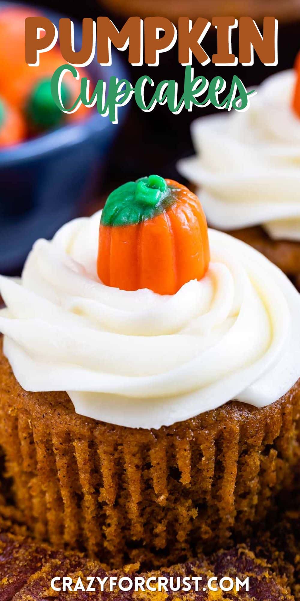 pumpkin cupcakes with white frosting and a candy corn pumpkin on top