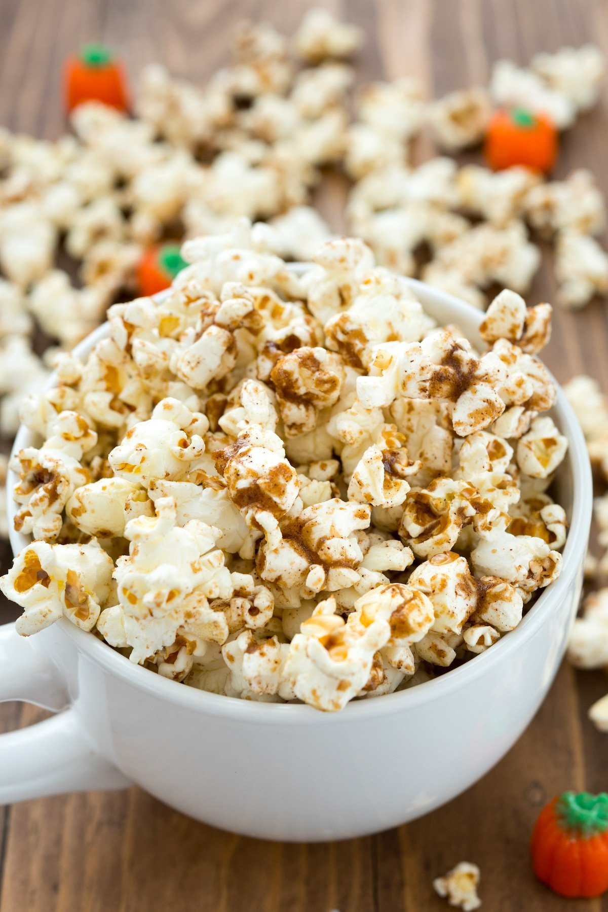 popcorn dusted with pumpkin spice in a white cup