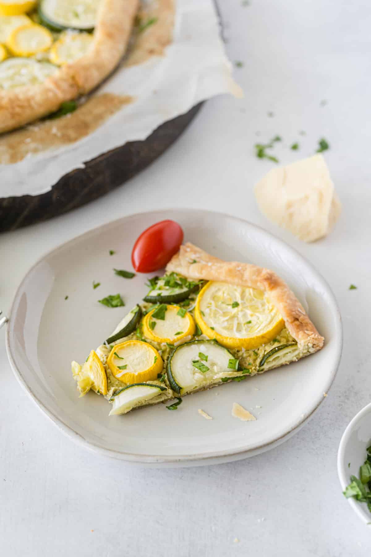 slice of galette topped with squash on a grey plate