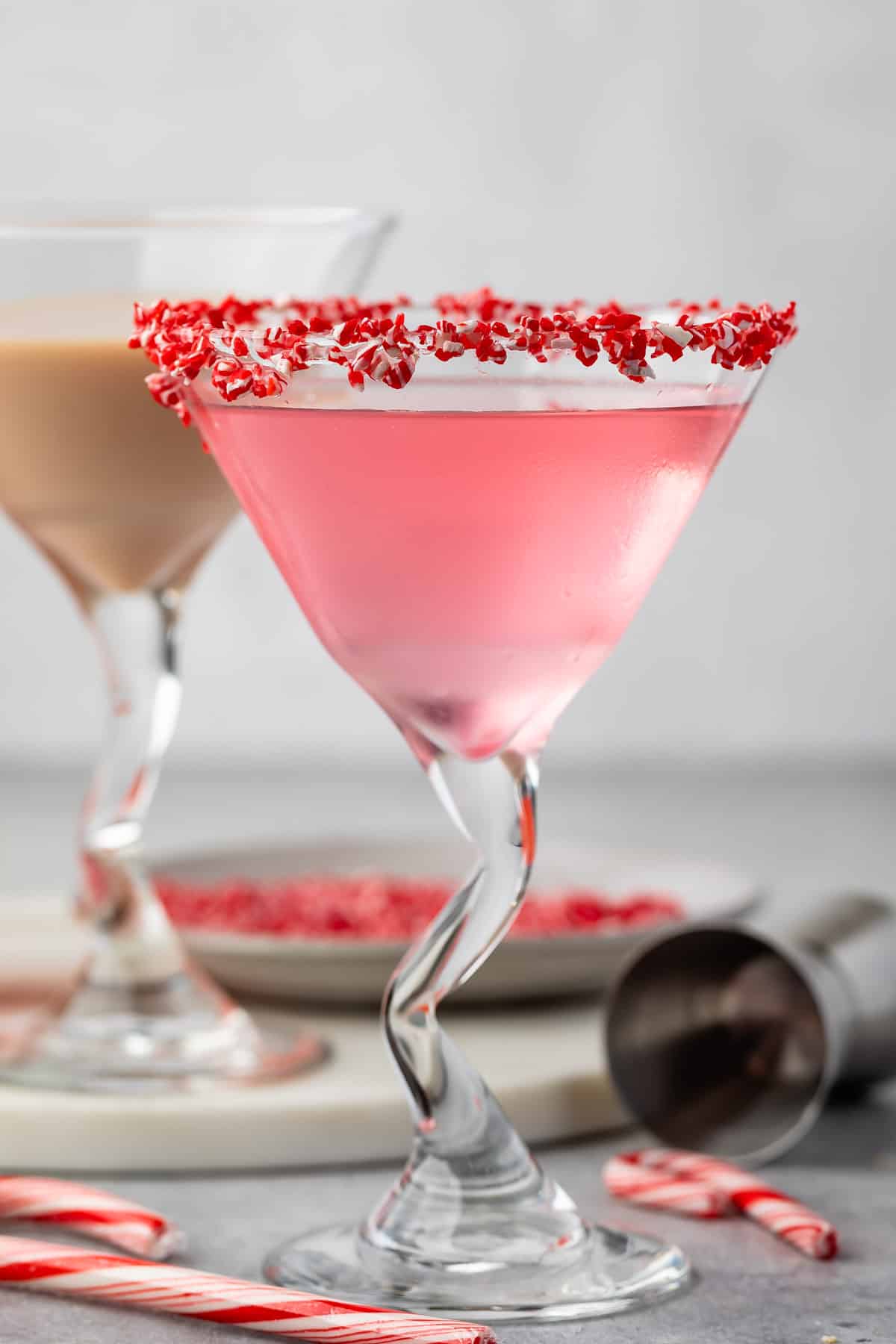 candy cane martini in a martini glass with crushed candy canes on the rim