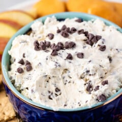 cookie dough in a dark blue bowl surrounded by cookies