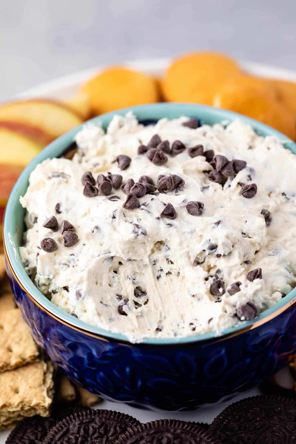 cookie dough in a dark blue bowl surrounded by cookies