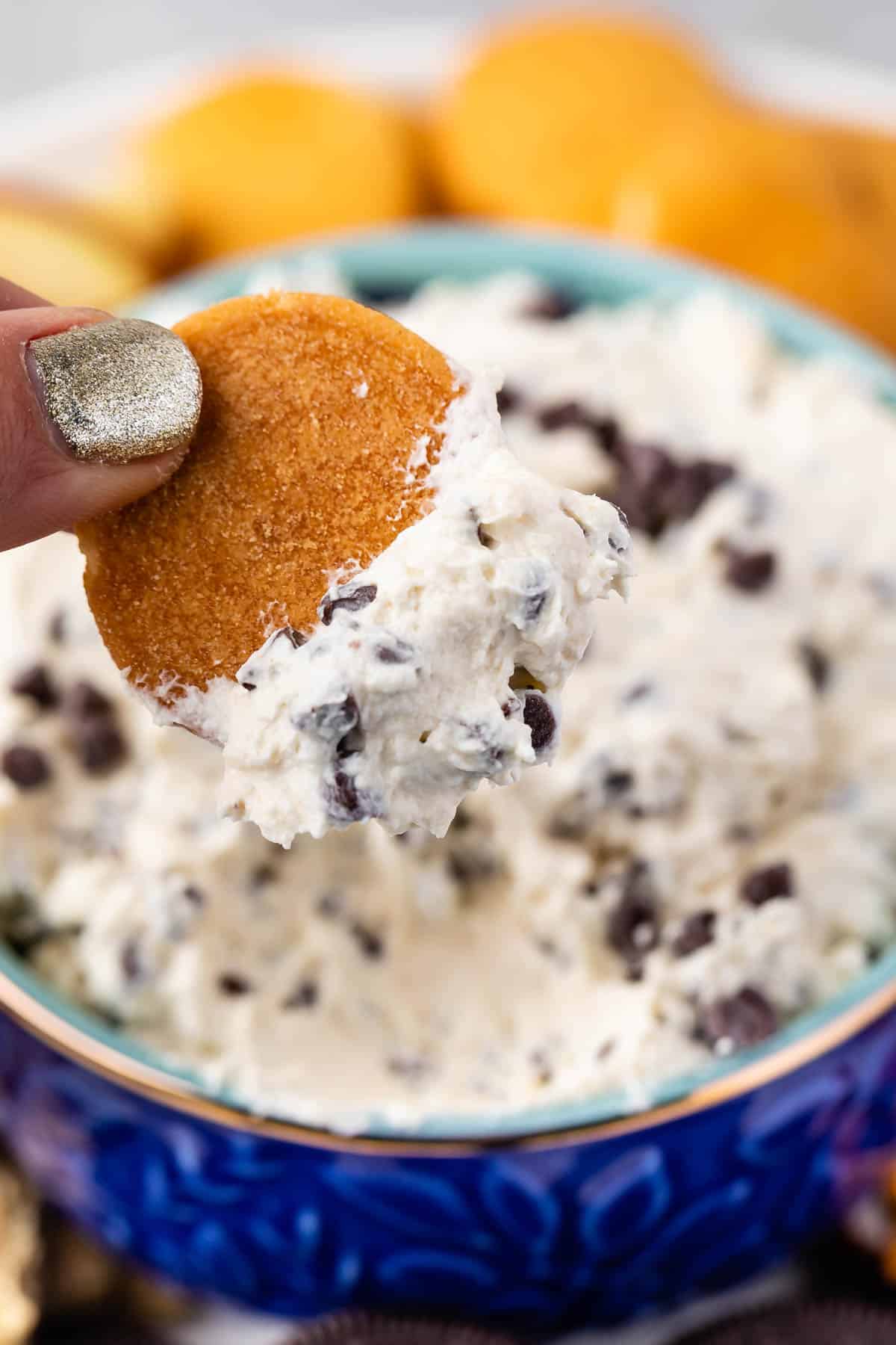 hand holding cookie dipped in cookie dough