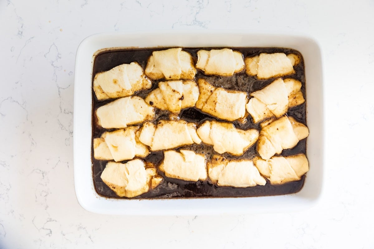 crescent rolls in white pan with sauce.