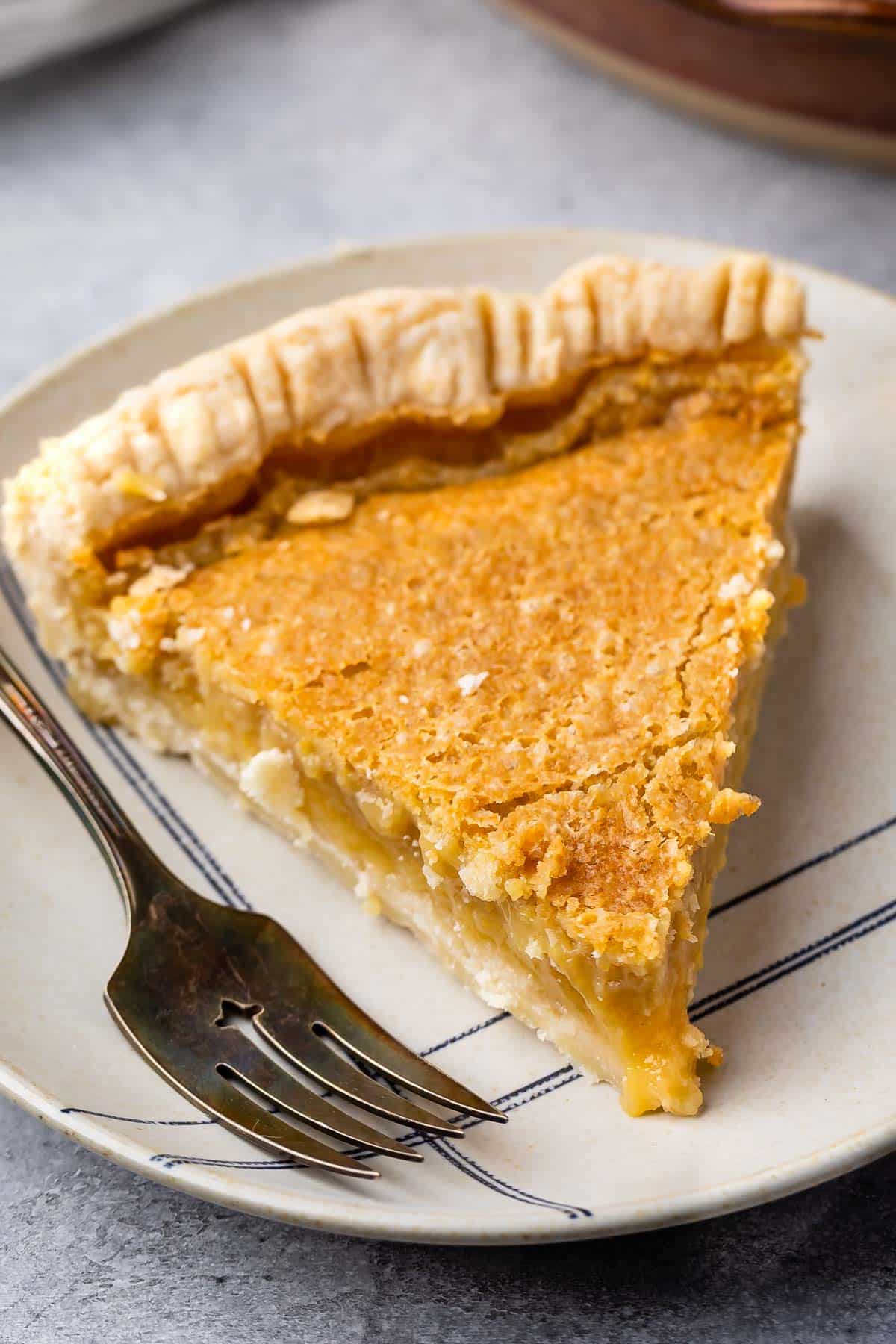 slice of maple chess pie on a tan plate next to a fork