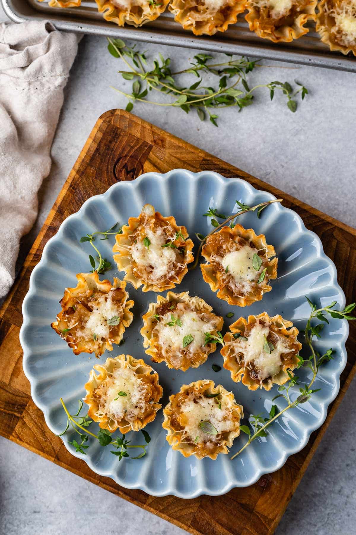 onion tarts on a blue plate with greens around them