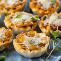 onion tarts on a blue plate with greens around them