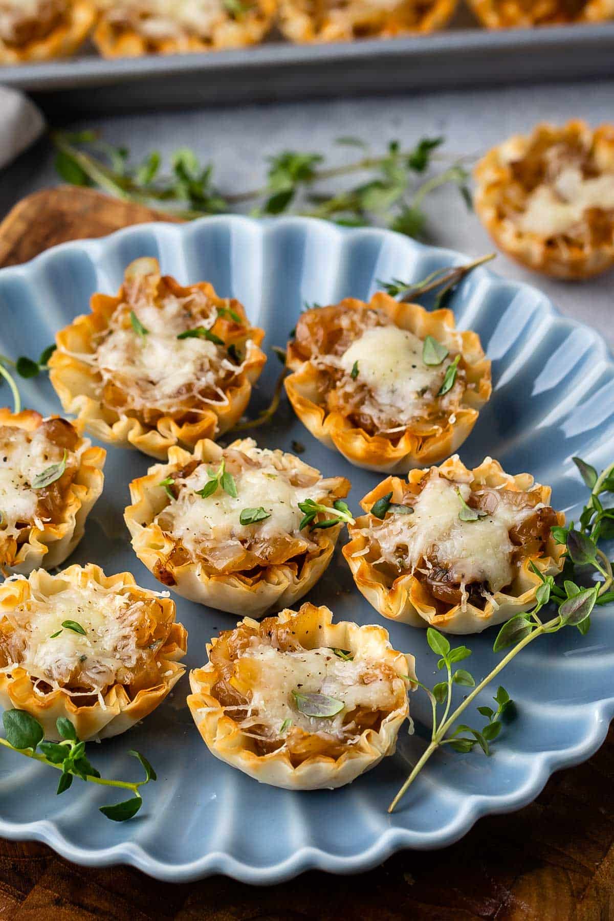 onion tarts on a blue plate with greens around them