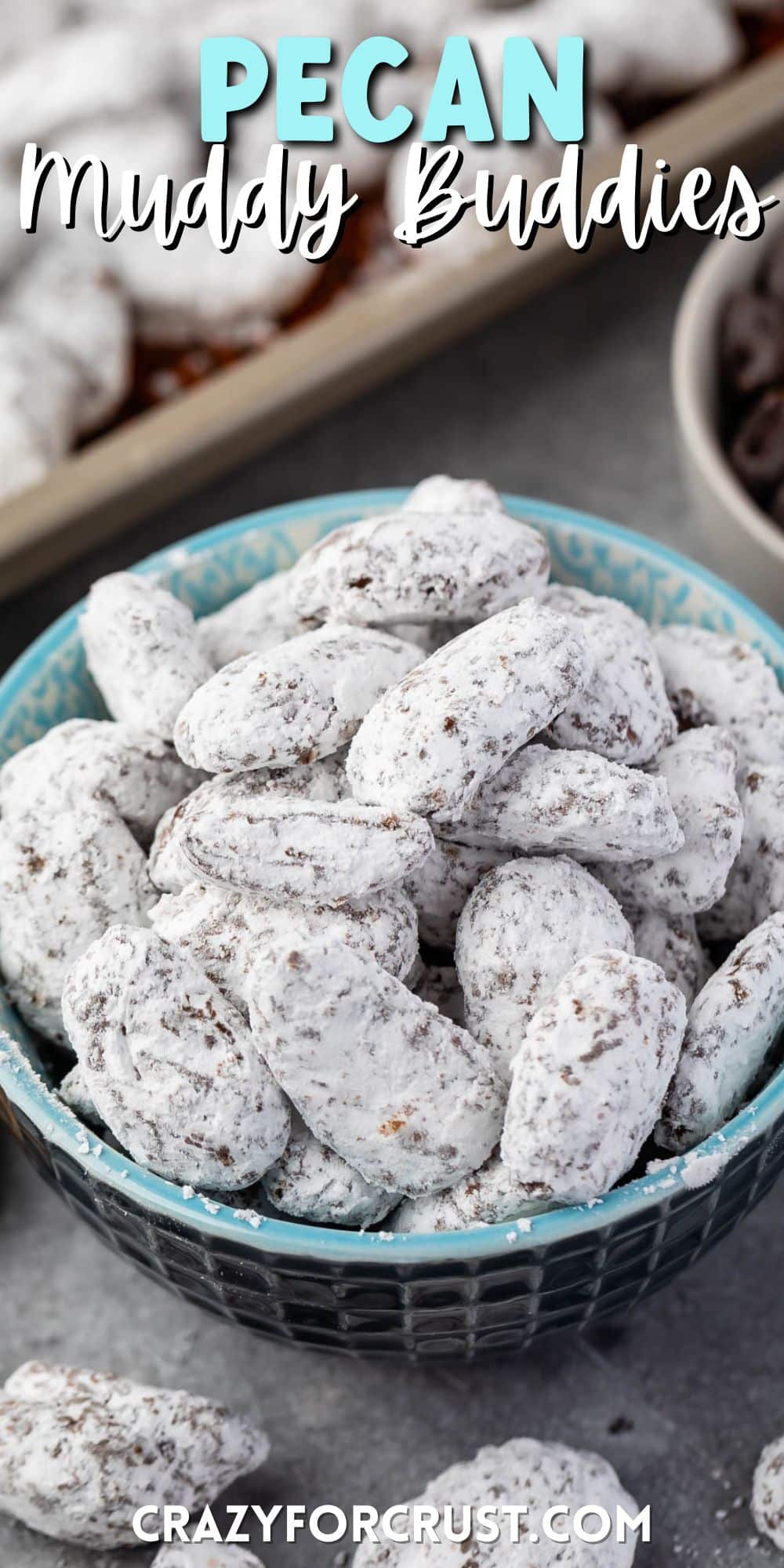 muddy buddies covered in powdered sugar in a blue bowl with words on top