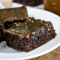 brownie on a white plate and topped with caramel