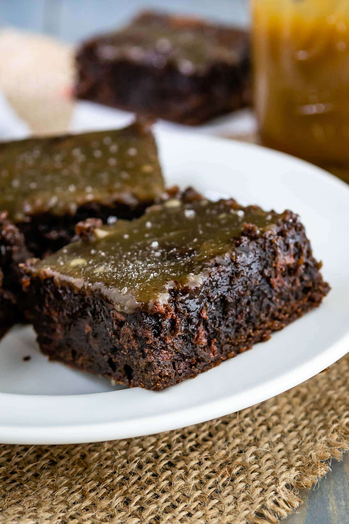 brownie on a white plate and topped with caramel