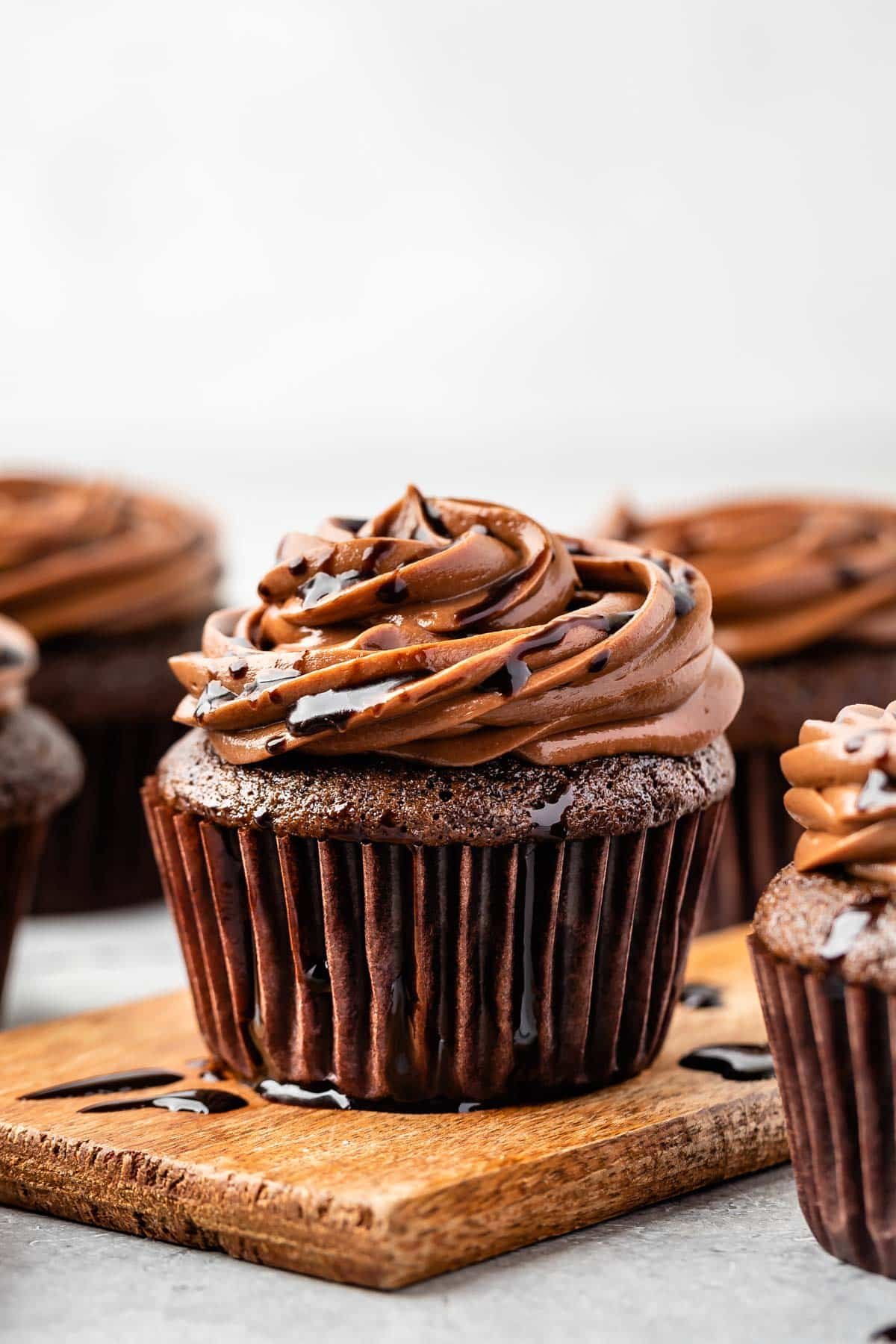 chocolate cupcakes on a counter with chocolate frosting