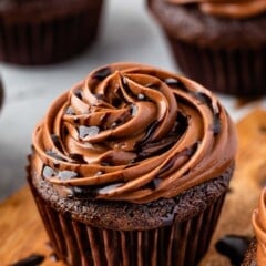 chocolate cupcakes on a counter with chocolate frosting