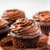 chocolate cupcakes on a counter with chocolate frosting