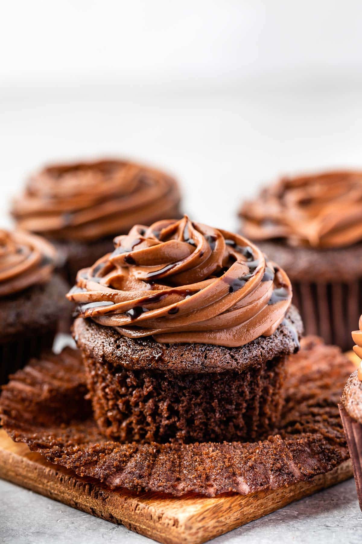 chocolate cupcakes on a counter with chocolate frosting