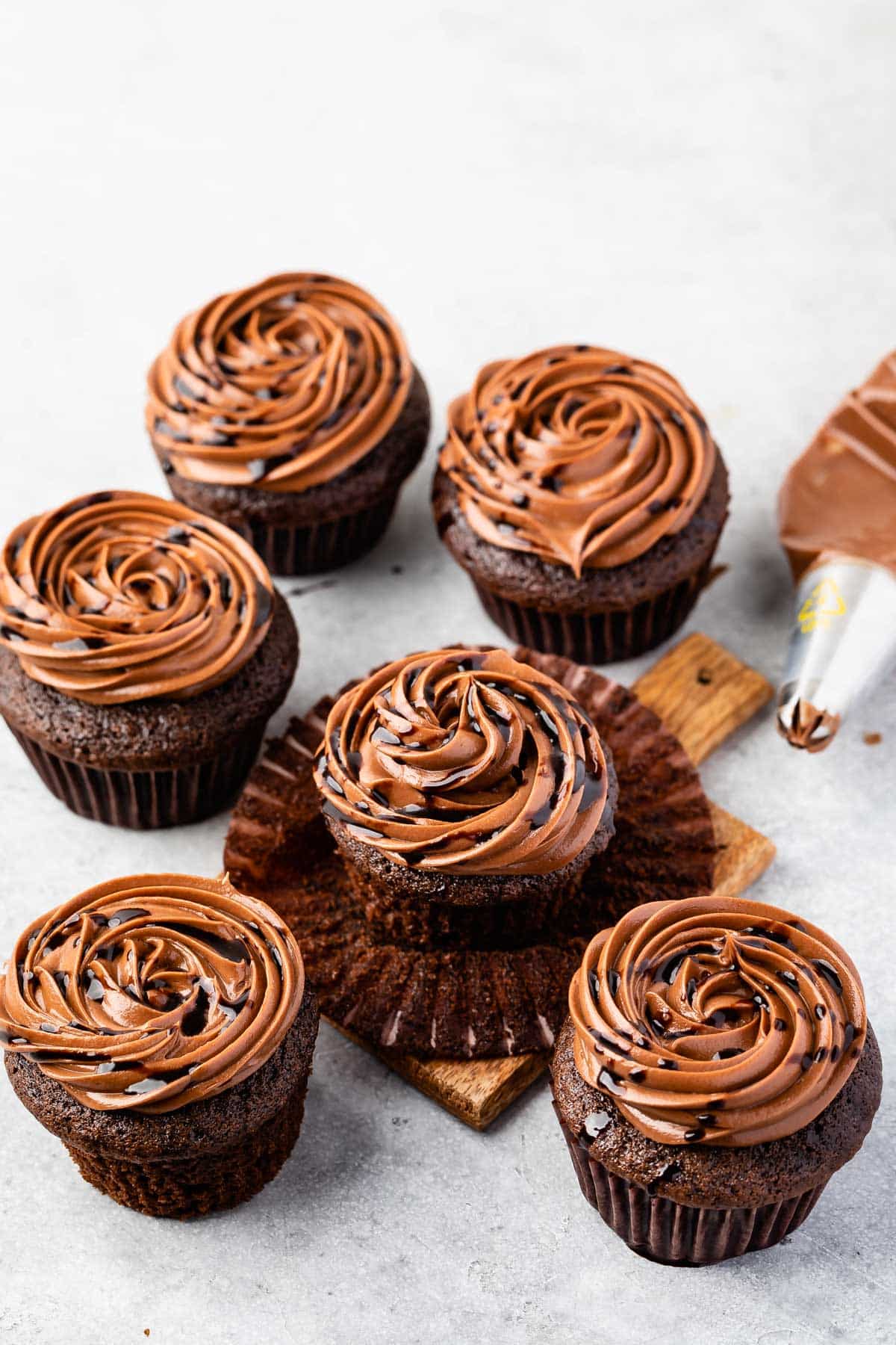 chocolate cupcakes on a counter with chocolate frosting